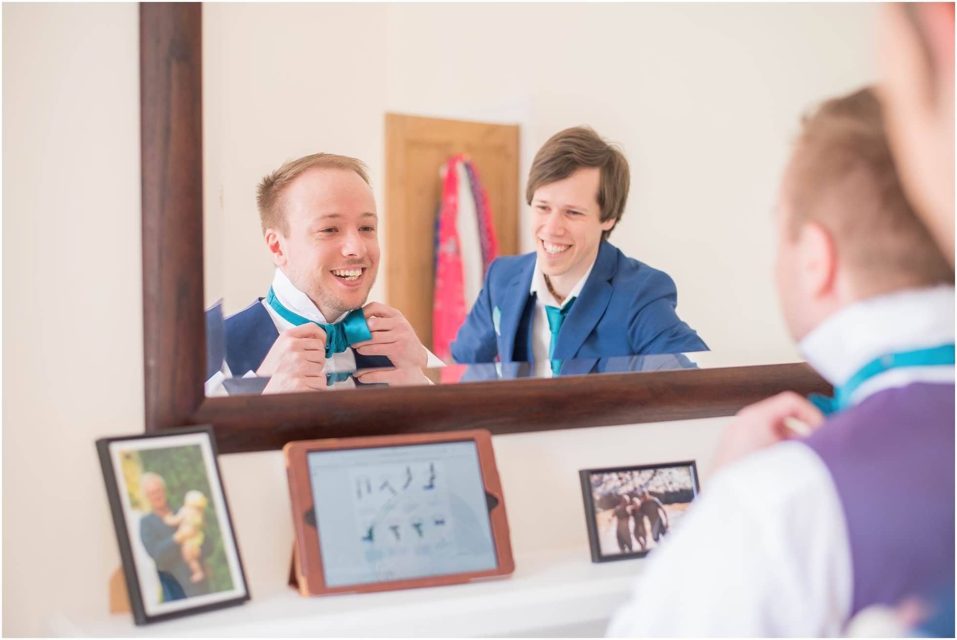 Groom and bestman trying to tie a bowtie in vain!