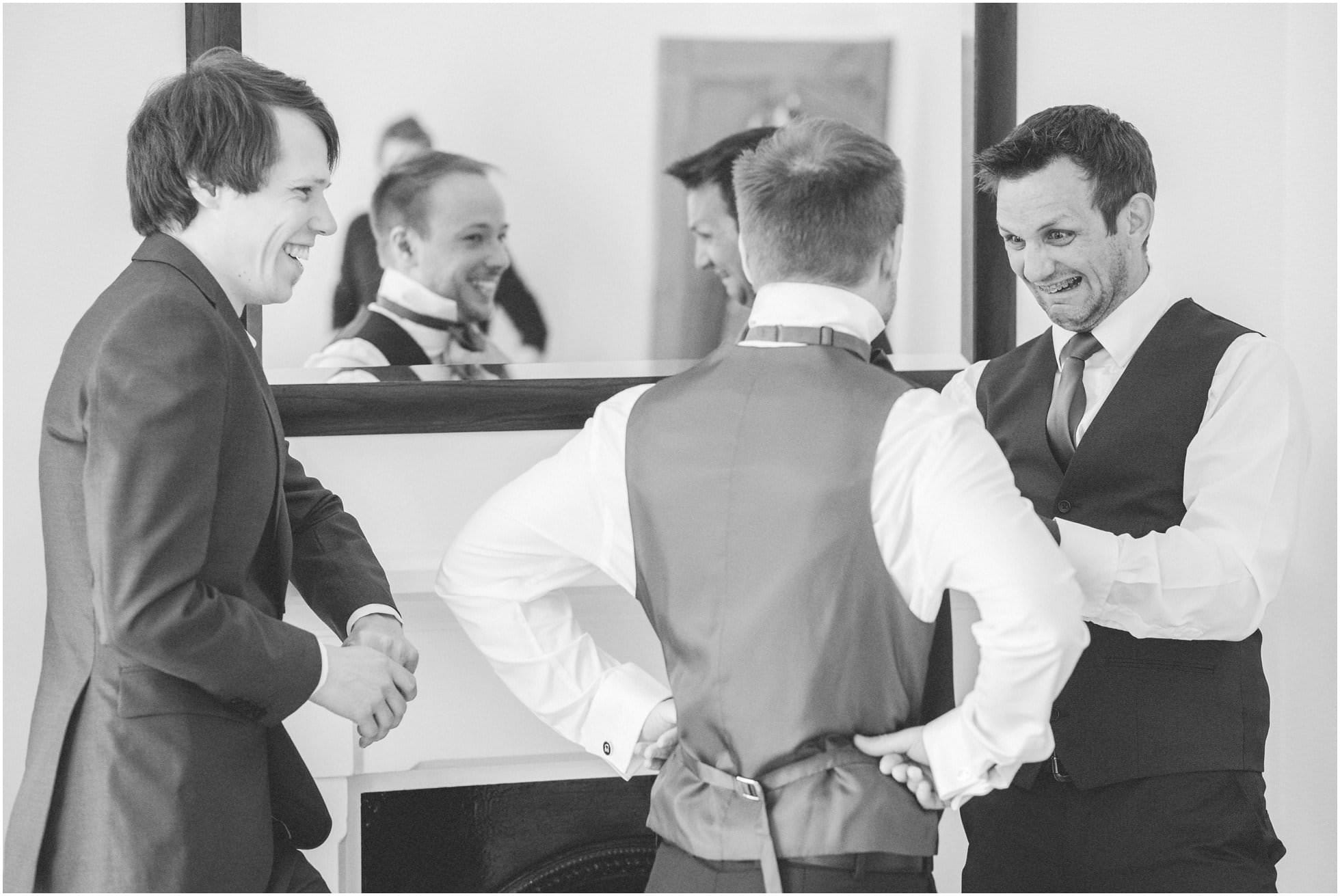 Groom and groomsmen trying to do up a bowtie