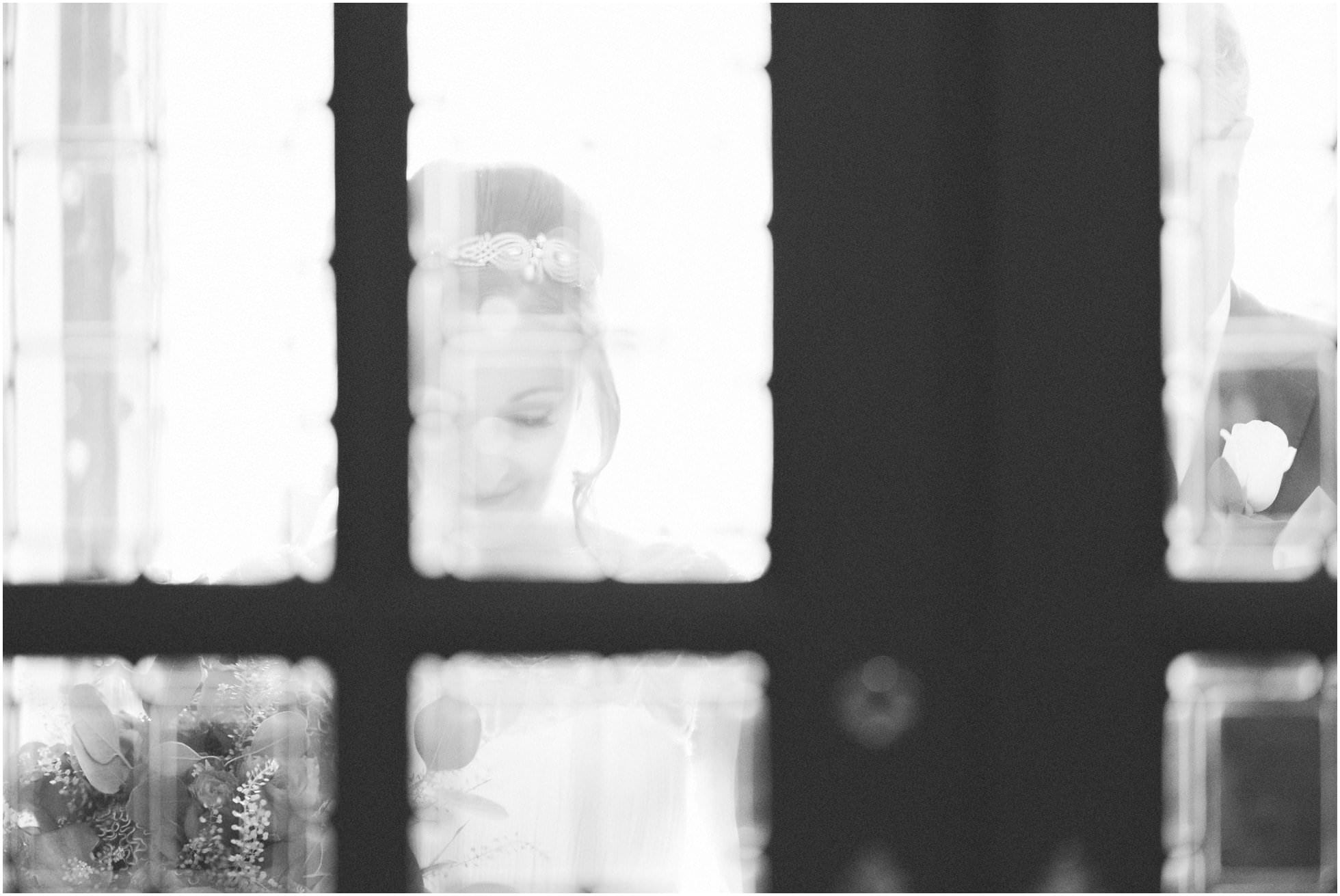 Bride through the glass of the church doors