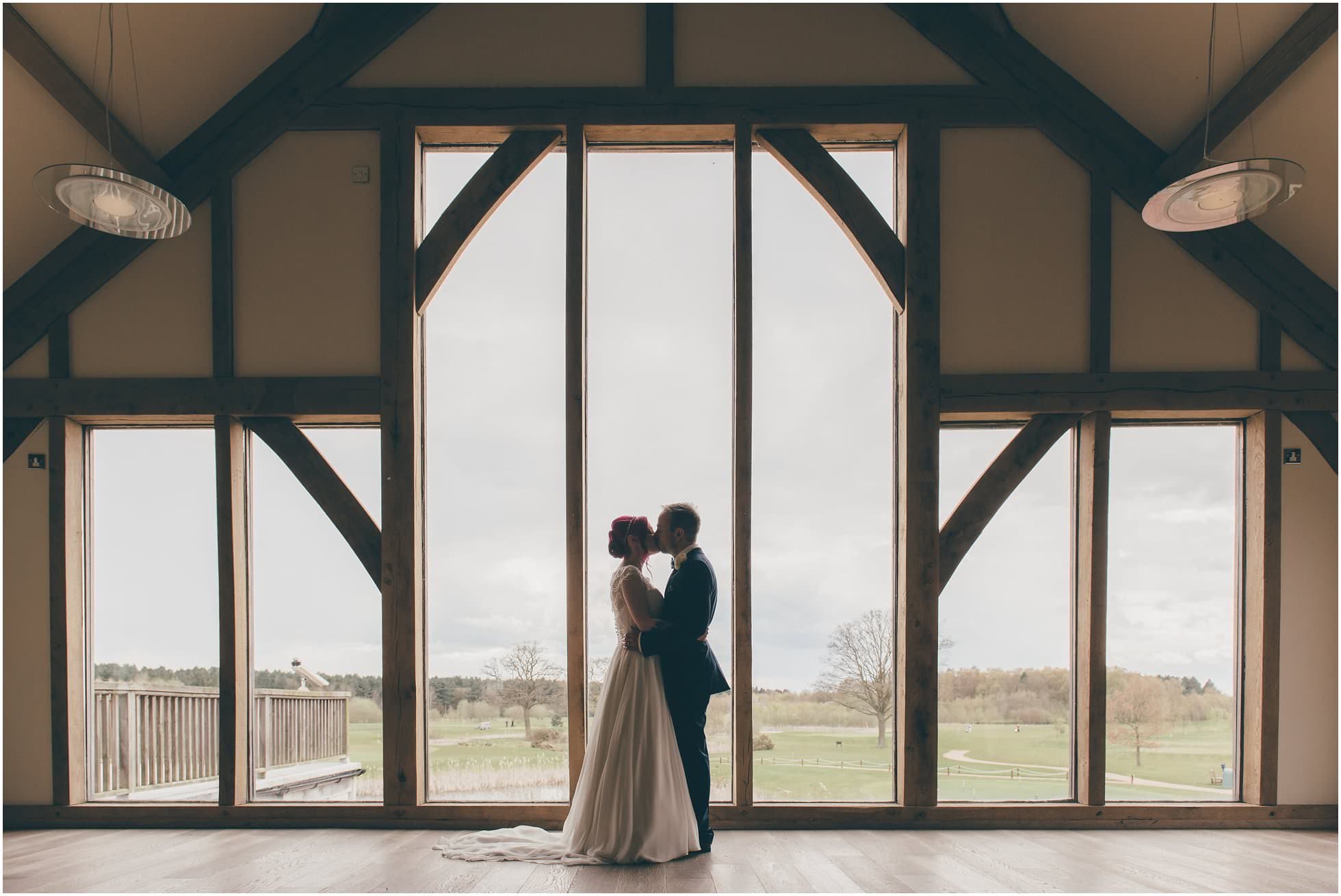 Gorgeous silhouette wedding shot in front of the big glass windows at Sandburn Hall