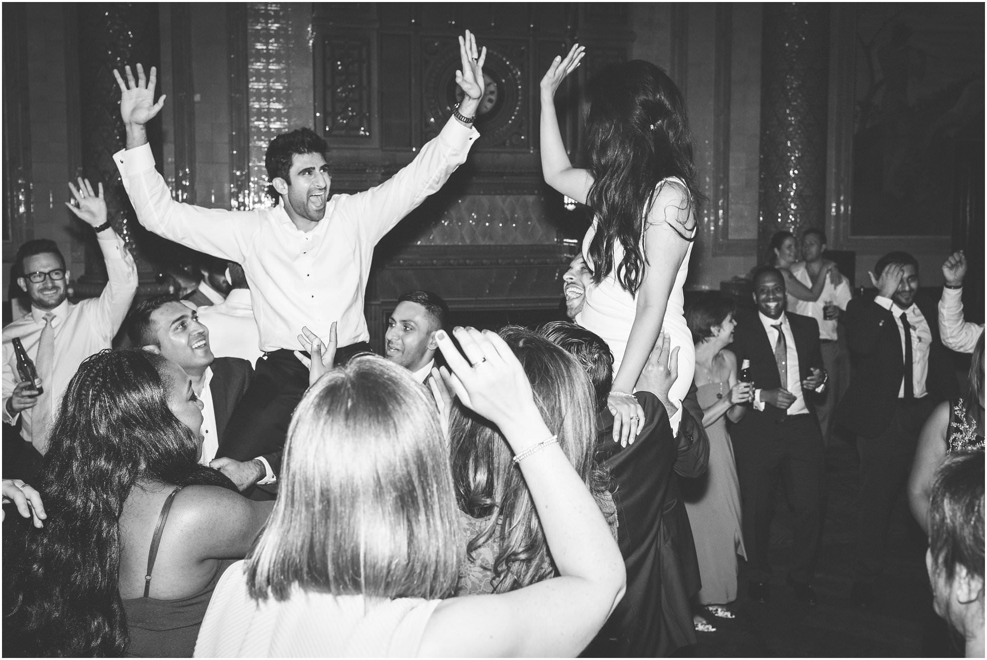 Bride and groom high five whilst being held up