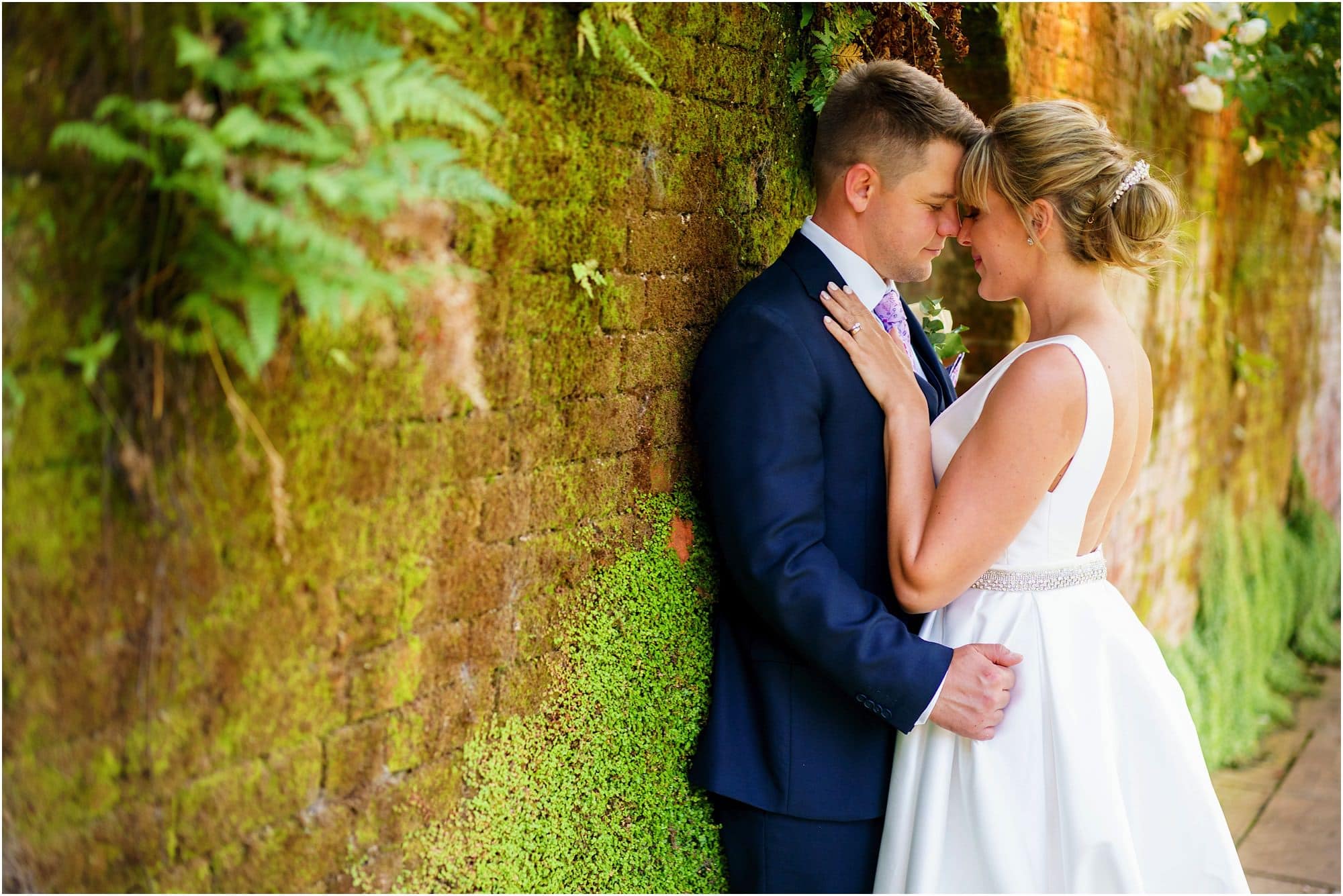 Woodhall Manor Wedding photo of bride and groom against a brick wall