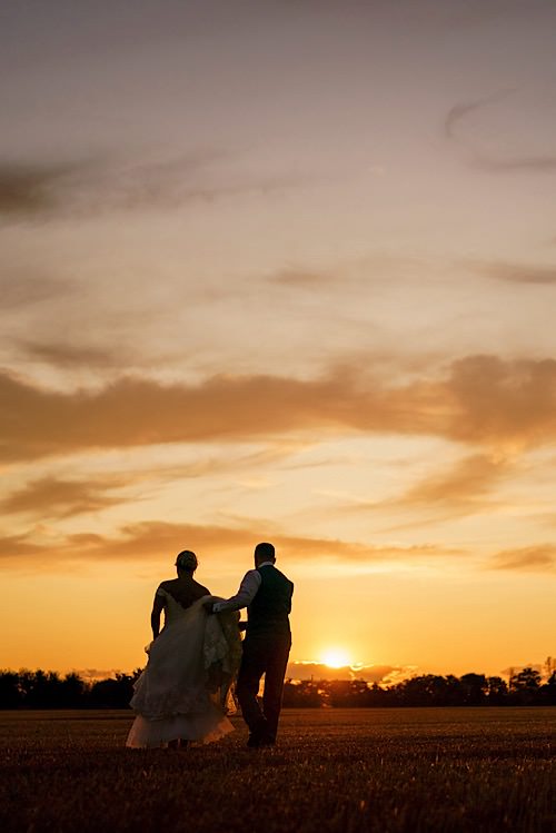 Bride and groom walking during golden hour in Norfolk