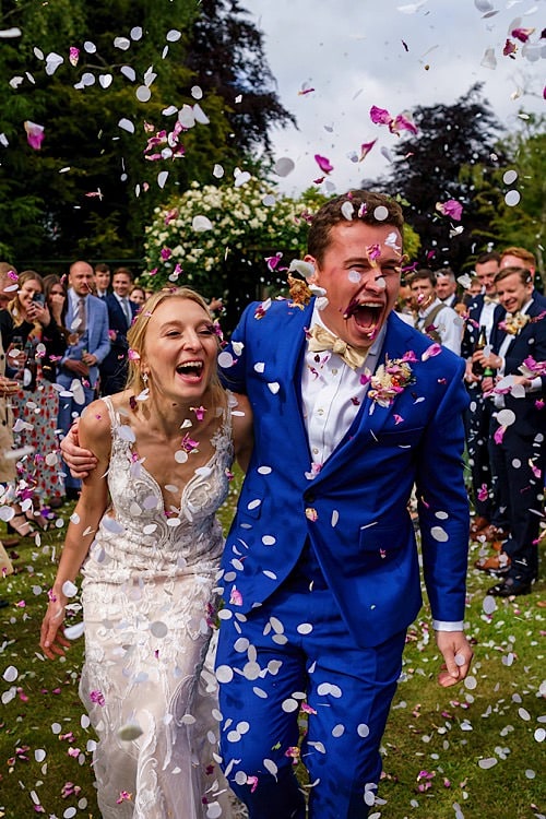 Wedding couple enjoying confetti in a Norfolk garden