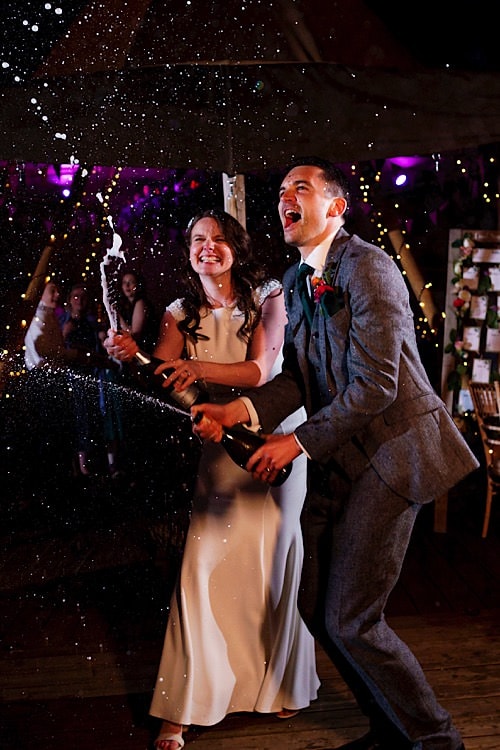 Bride and groom spraying champagne at a Norfolk wedding