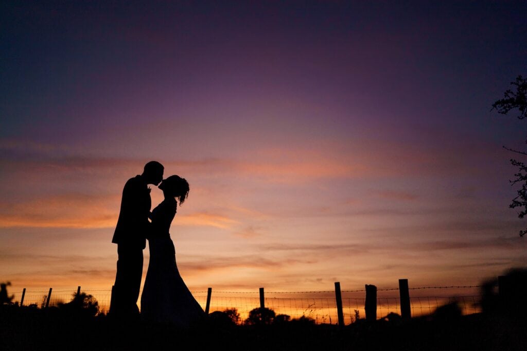 Beautiful sunset with silhouette of married couple