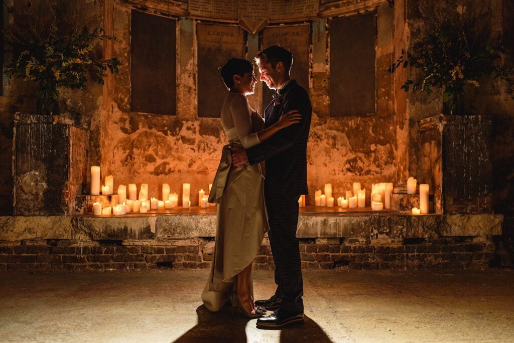Wedding couple in front of candles in a chapel