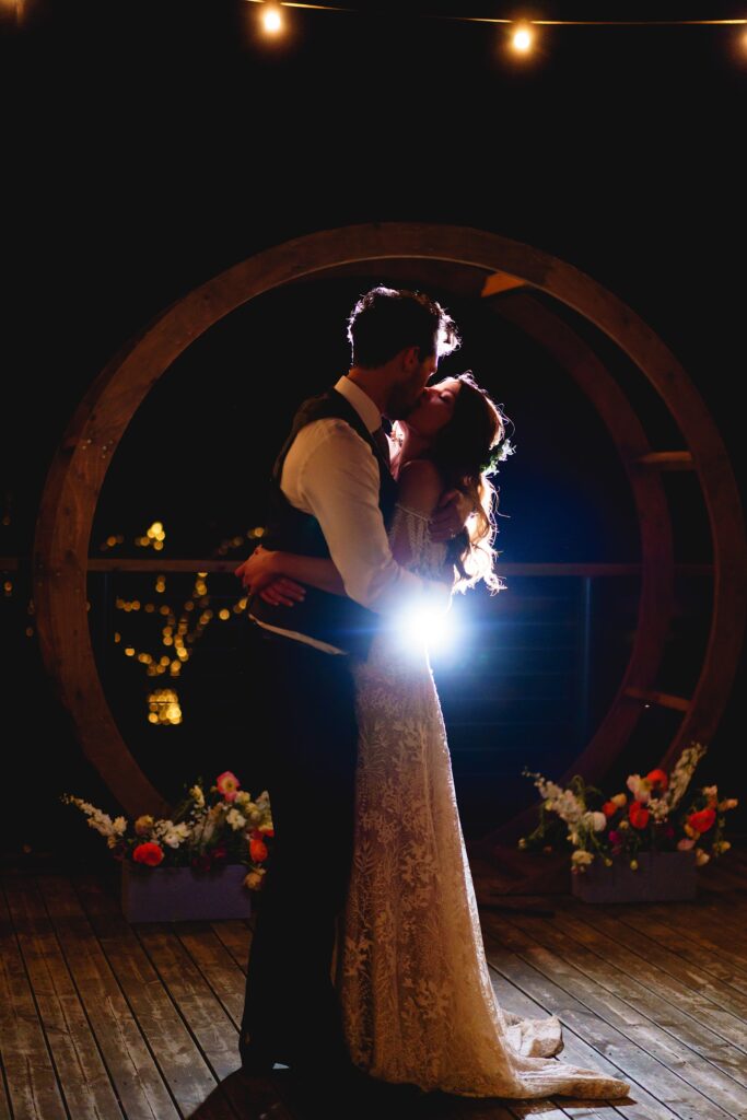 Bride and groom kissing at night