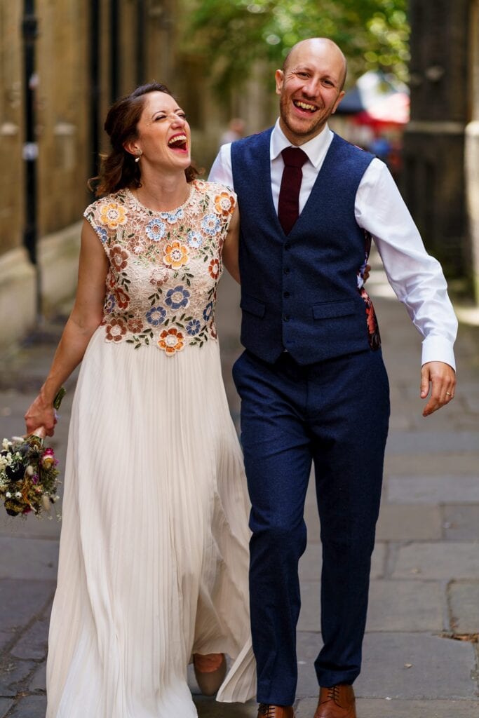 Wedding couple walking arm in arm and laughing