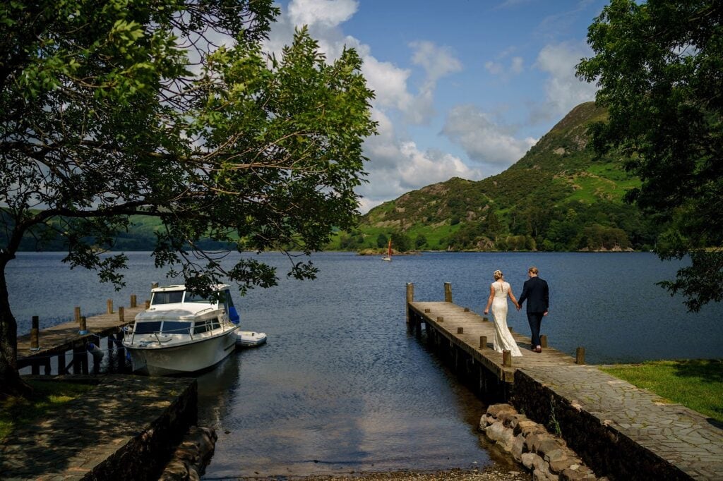 Wedding couple walking out to a lake hand-in-hand