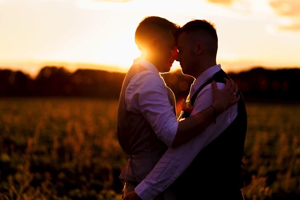 gay couple having a hug at sunset