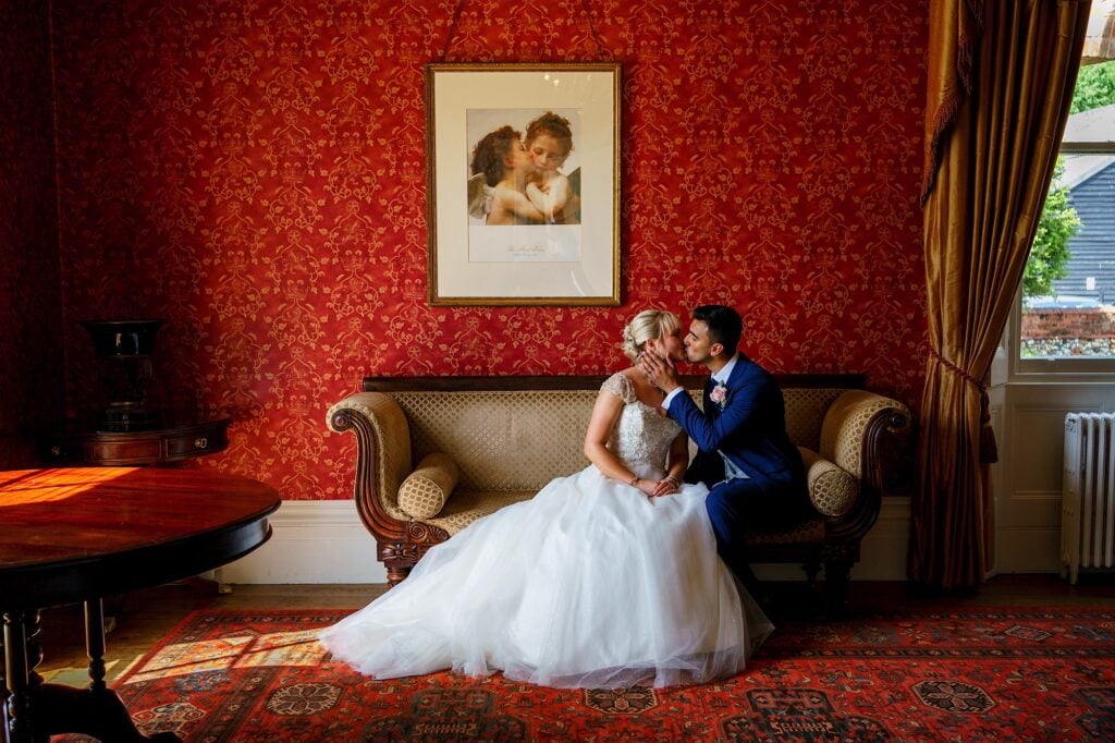 Bride and groom kissing on a sofa