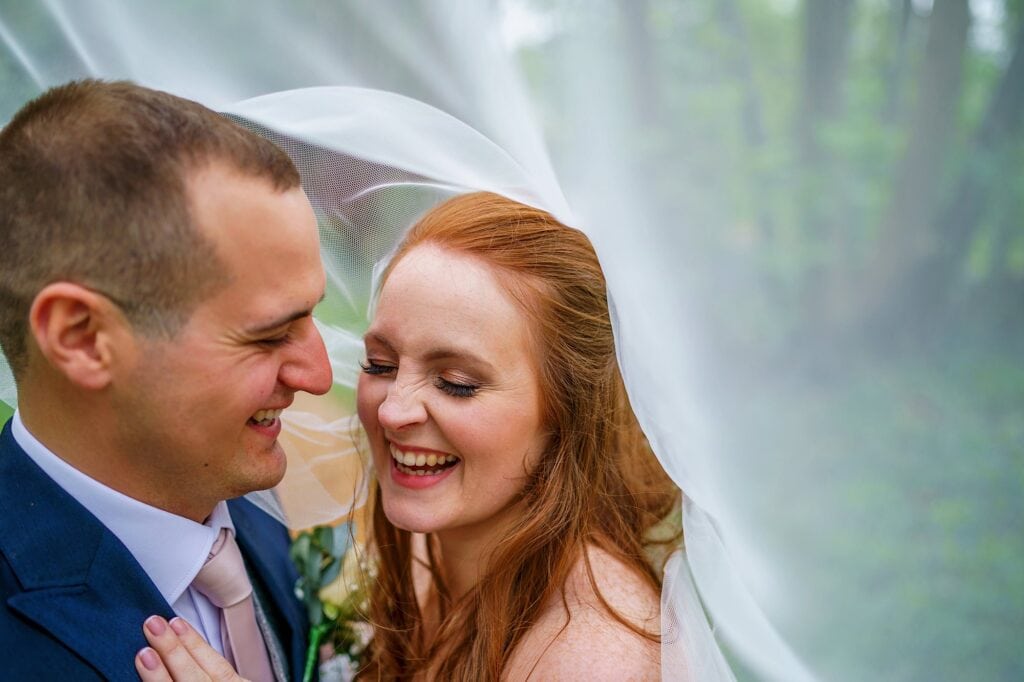 couple laughing under a veil