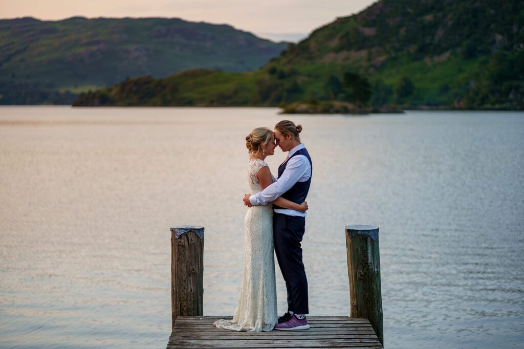Bride and groom on the end of a pier at dusk