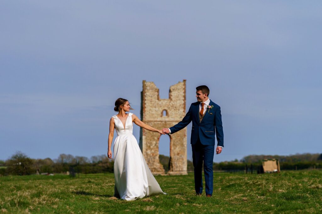 Wedding couple walking away from the ruins at Godwick