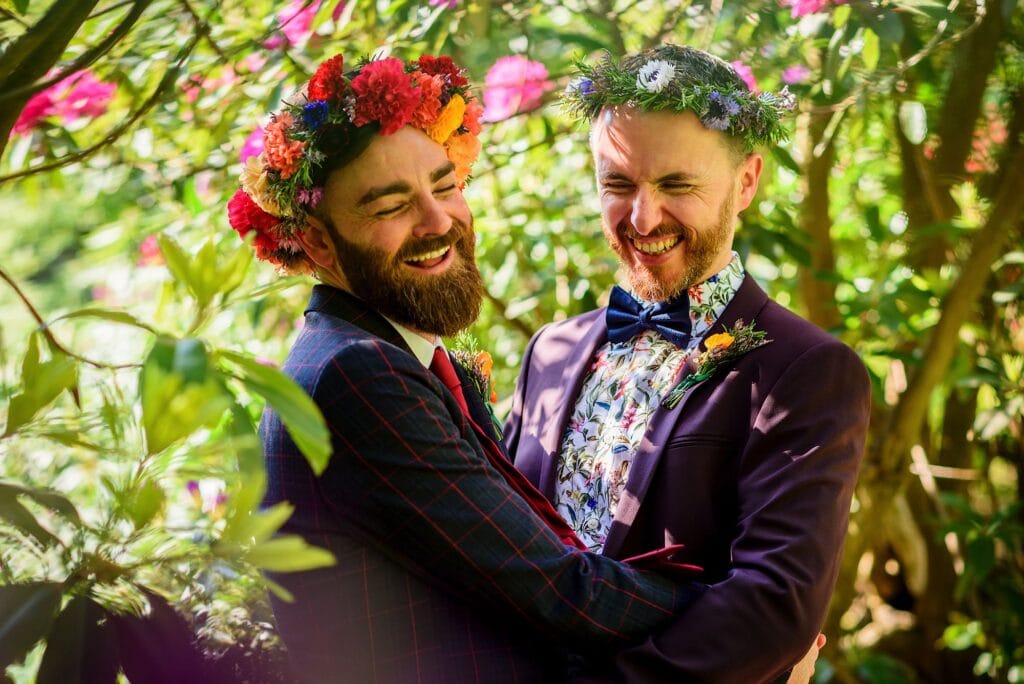 Gay couple wearing flower crowns and laughing