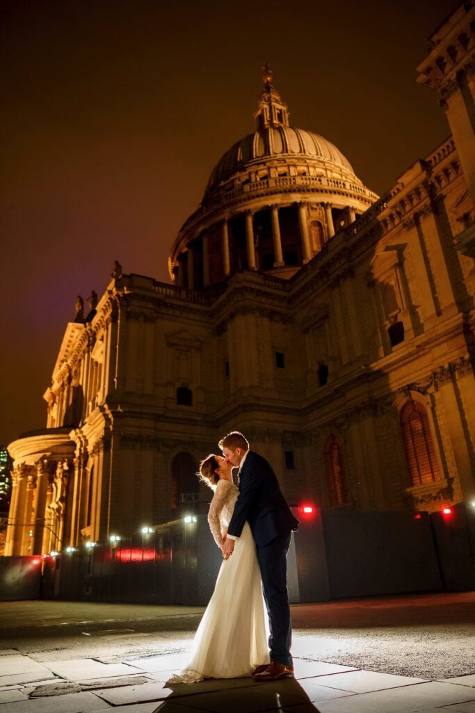 Bride and groom kissing in front of St Paul's Chapel