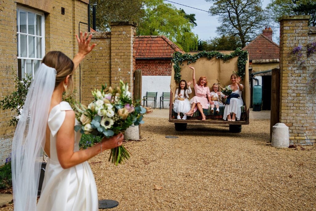 Bride waving to family on the back of the Godwick tractor trailer