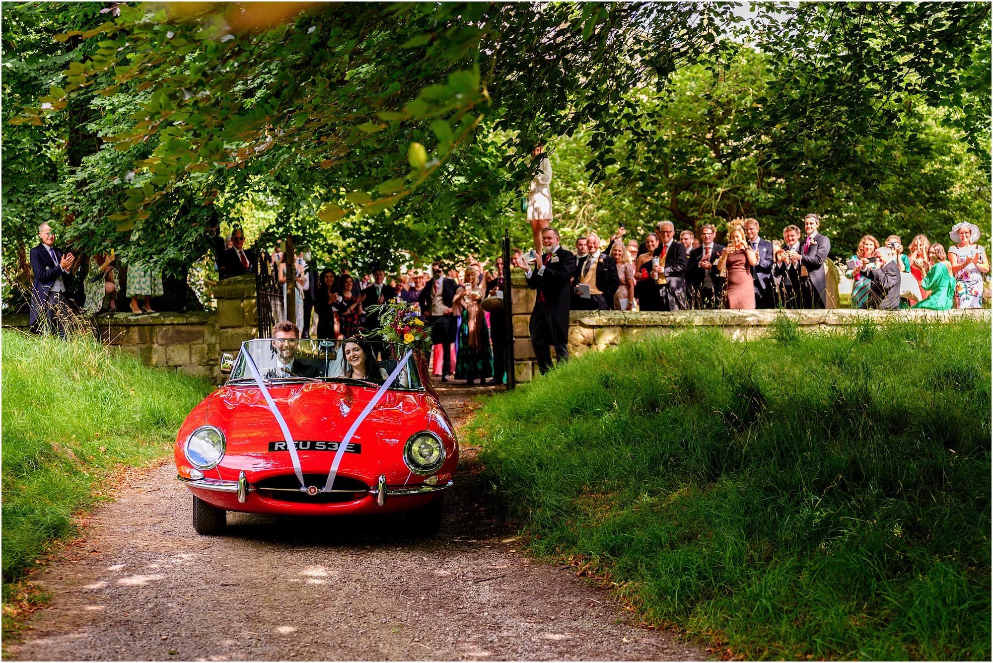 Leaving wedding in a classic red e-type jag