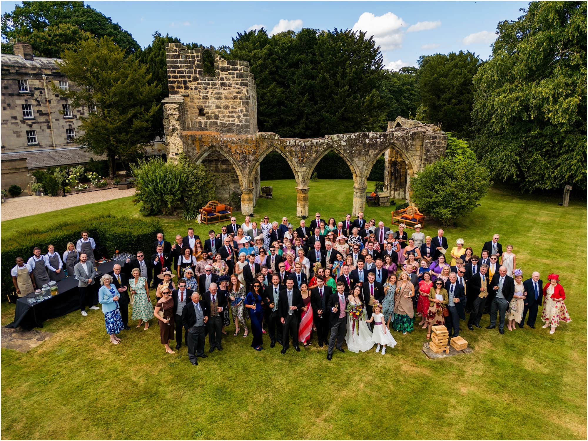 Full wedding party group shot in front of Birdsall ruins