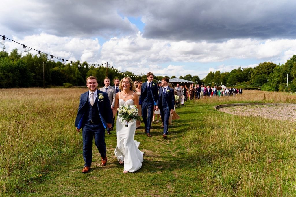 Bride and groom smiling and walking straight after their wedding ceremony at wellington wood