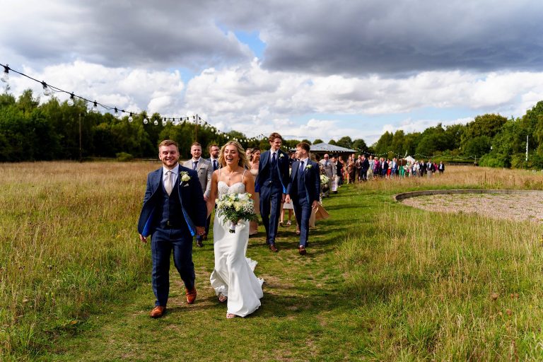 Bride and groom smiling and walking straight after their wedding ceremony at wellington wood
