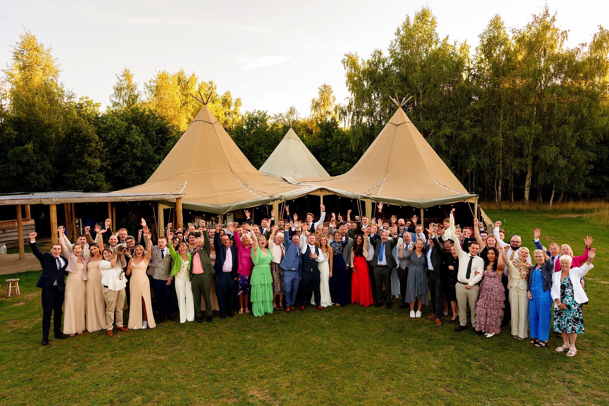 full wedding group shot in front of the wellington wood tipi