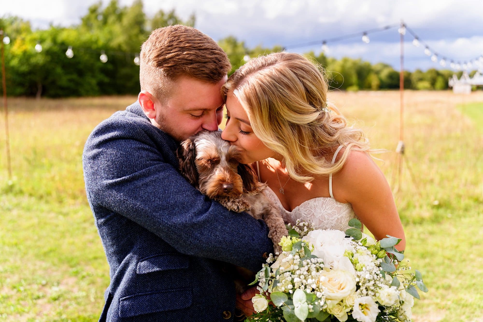bride and groom kissing their dog