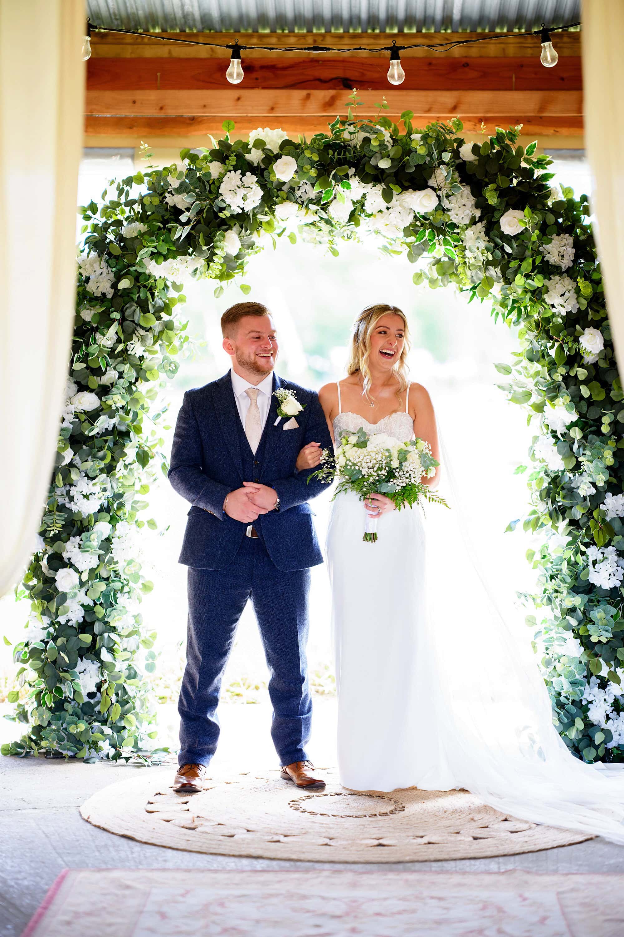 bride and groom smiling during the ceremony at Wellington Wood