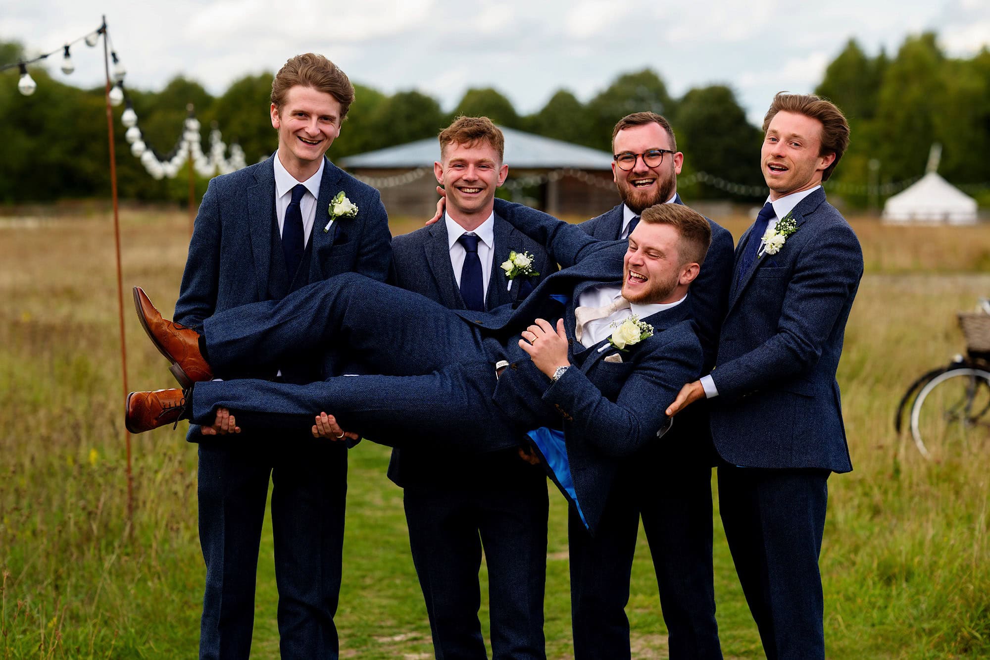 groomsmen picking up the groom